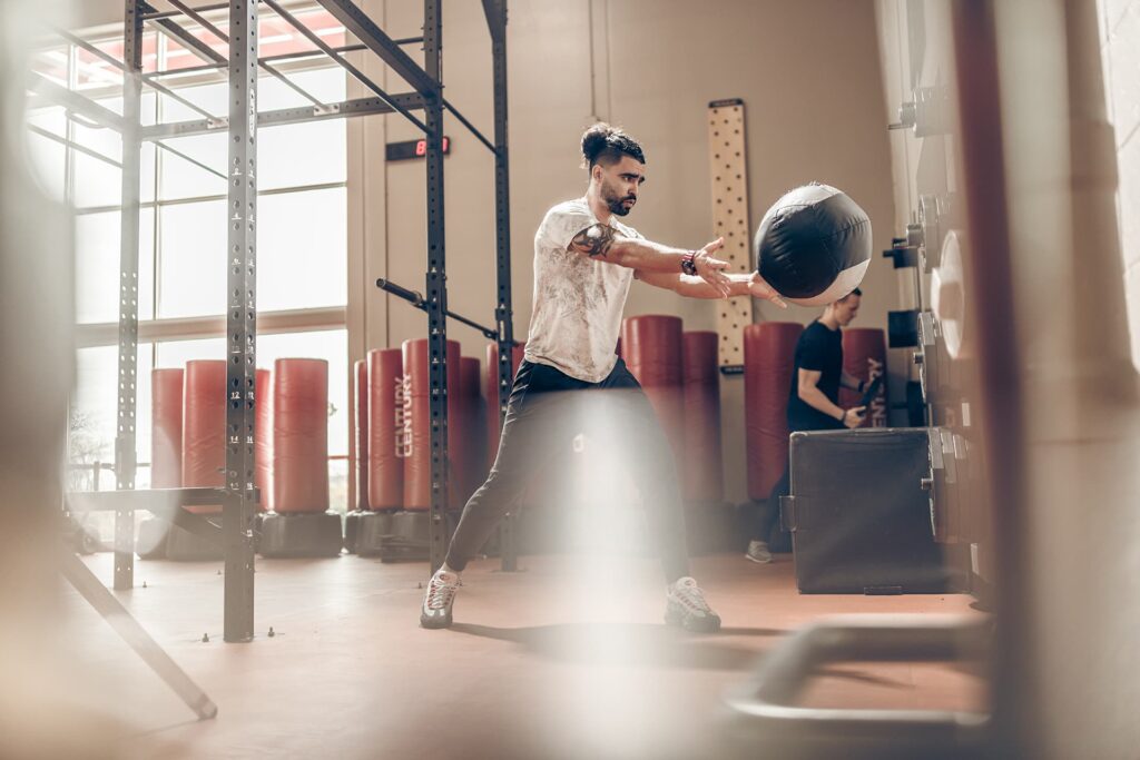 Man does ball slams at a fitness center