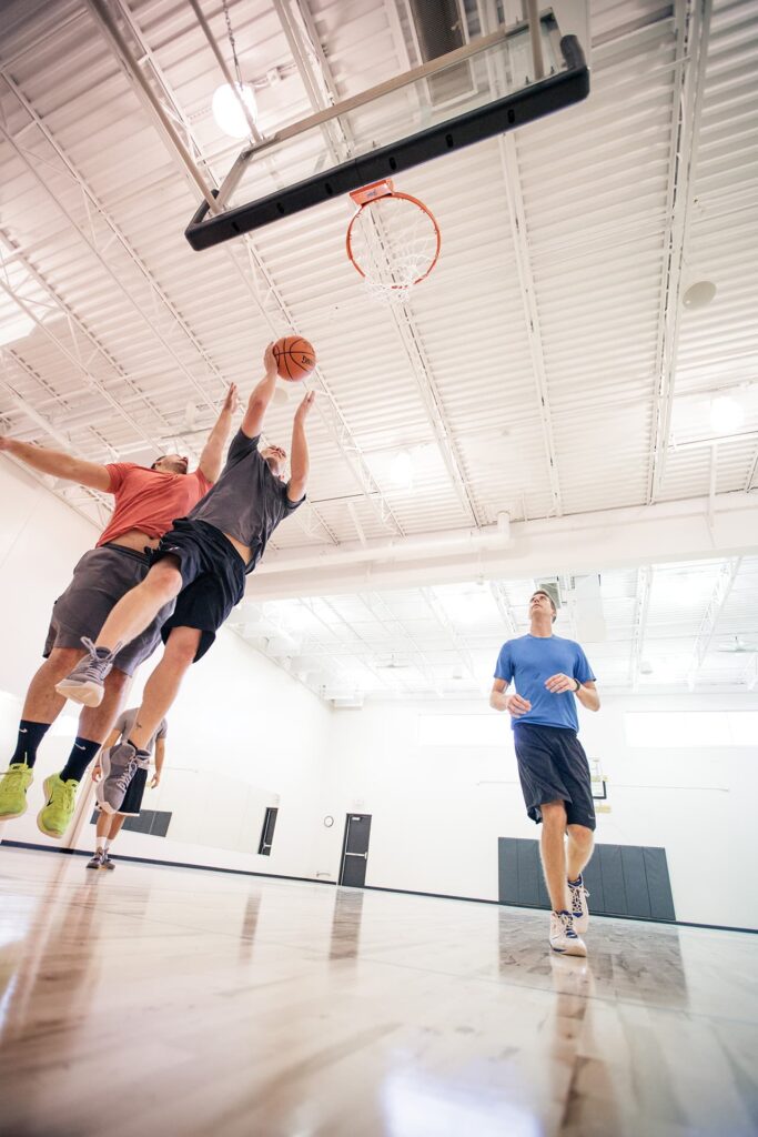 A group of friends plays basketball at the gym