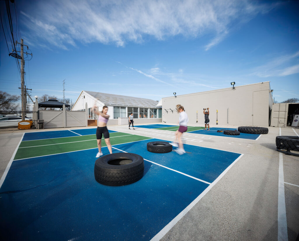 Woman uses a sledgehammer on a tire in the Yard at the WAC West Allis