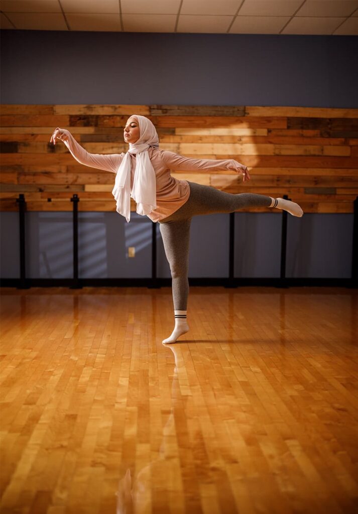 Woman does dance barre workout in a studio