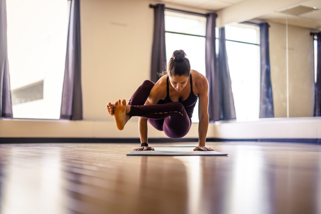 Woman does advanced yoga pose in an open studio